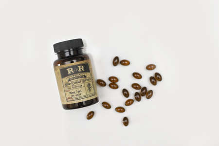 A closeup shot of brown medicine pills and bottle on a white backgroundのeditorial素材