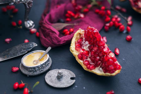 A slice of fresh pomegranate surrounded by its seeds placed on a blue smooth surfaceの写真素材