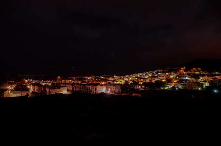 A beautiful view of lights in canary islands in spain with a dark night sky in the background