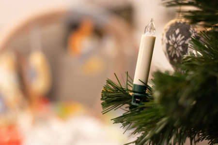 A selective focus shot of a LED candle in the christmas tree with a blurred backgroundの写真素材