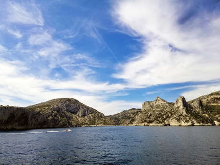The Massif des Calanques surrounded by the sea under a blue sky and sunlight in Franceの写真素材
