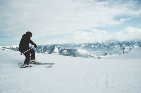 A beautiful shot of a man skiing on the mountains covered with whiteの写真素材