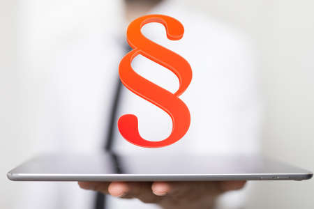 A lawyer working with a virtual projection of a digital paragraph law symbol