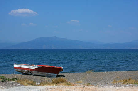 A small wooden boat on a shore of a lake-a good backgroundの写真素材