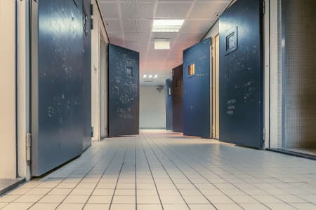 A low angle shot of rooms with doors wide open along a tiled hallwayのeditorial素材