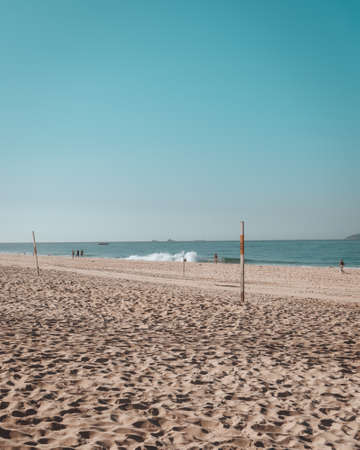 A beach surrounded by people and the sea under the sunlight in Rio de Janeiro in Brazilのeditorial素材