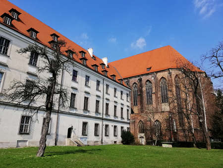 A bottom view shot of a building and a small garden with trees next to it in Warsaw, Polandのeditorial素材
