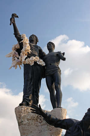 A vertical shot of a statue of two men next to each other under a blue skyのeditorial素材