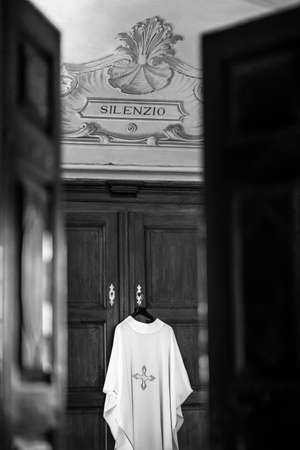 ALBA, ITALY - May 15, 2018: image of a priest's dress in a church under the inscription "silence"のeditorial素材