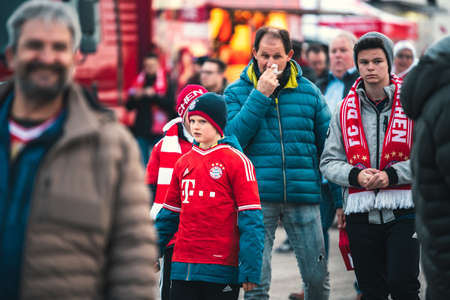 MUNICH, GERMANY - Jan 25, 2020: Young football fan kids going to see a soccer match of famous german club FC Bayern Munich. Exited fans walking to Allianz Arena.のeditorial素材