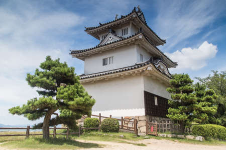 A low angle shot of the magnificent Uwajima Castle captured under the blue sky in Japanのeditorial素材