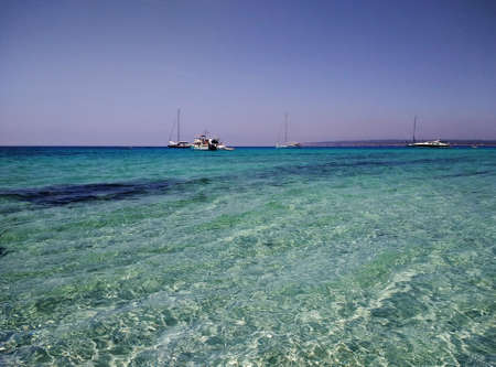 A beautiful shot of the water surface and boats floating in back in Formentera, Spain
