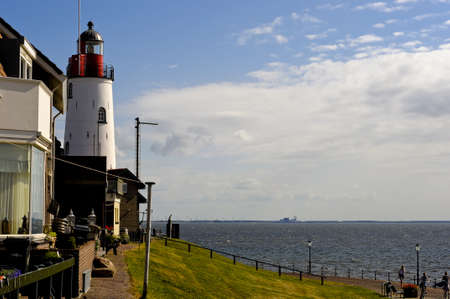 A beautiful shot of Urk Lighthouse in the Netherlands with a cloudy blue sky in the background