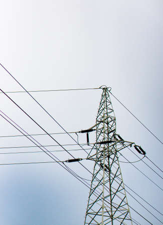 A bottom view shot of a transmission tower with a cloudy sky in the background