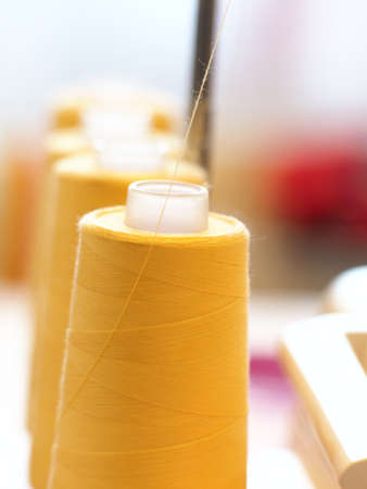 A vertical shot of sets of orange thread next to each other