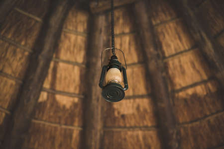 A low angle shot of a lamp hanging inside a cabin with a blurred backgroundの写真素材