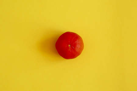 An overhead shot of the red mandarin on the yellow backgroundの写真素材