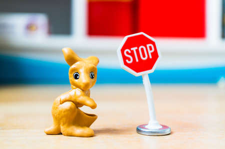 POZNAN, POLAND - Feb 15, 2019: Plastic toy kanagaroo figurine and a stop board in soft focus...