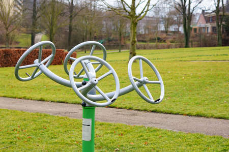 A wide angle shot of a metal instrument with steering wheels attached in a park