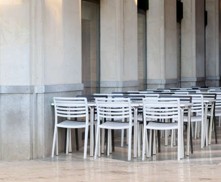 A cafe with white chairs and tables during daytimeの写真素材