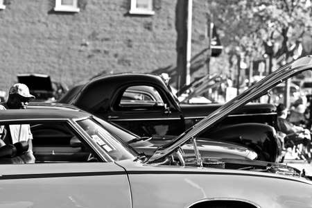 DOWNERS GROVE, UNITED STATES - Jun 07, 2019: A grayscale shot of different models of cars parked in a parking lotの写真素材