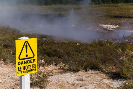 A yellow danger sign with a blurred backgroundの写真素材