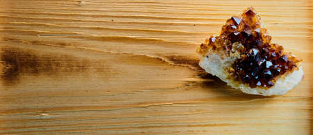 A high angle closeup shot of a crystal piece on a wooden surfaceの写真素材