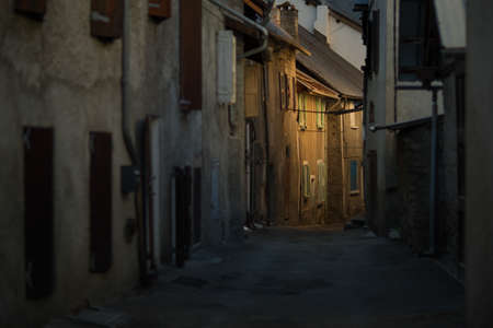 An Alley surrounded by buildings with the lights during the evening
