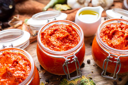 A closeup of raw ajvar on the table with vegetables and sauces on the backgroundの写真素材