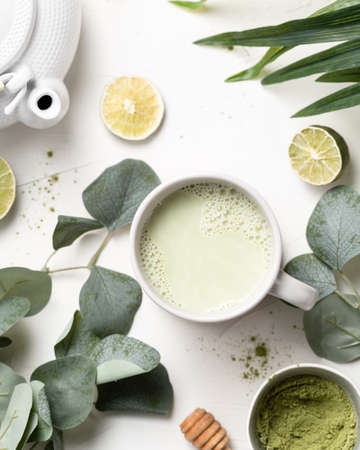 A green matcha tea leaves and limes on a tableの写真素材