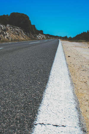 A vertical shot of the white paint on the edges of the roadの写真素材