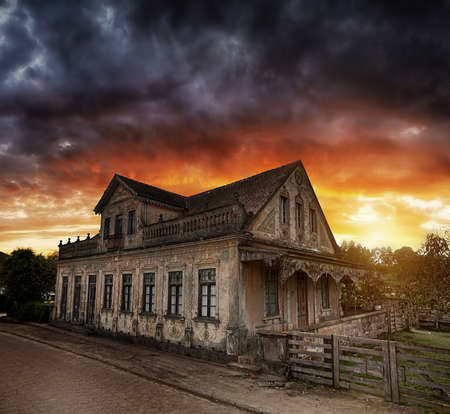 A dark old house with clouds on hanging on itの写真素材