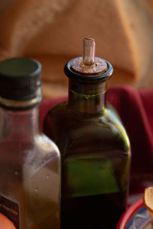 a closeup shot of an olive oil bottle capped with cork stopper with a spout