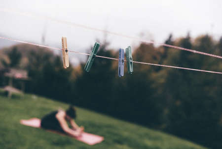 A selective focus shot of plastic clothespins hanging on the ropeの写真素材