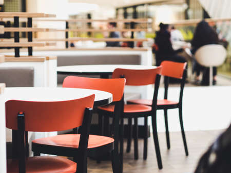Chairs and tables of a restaurant in a shopping mall in soft focusの写真素材