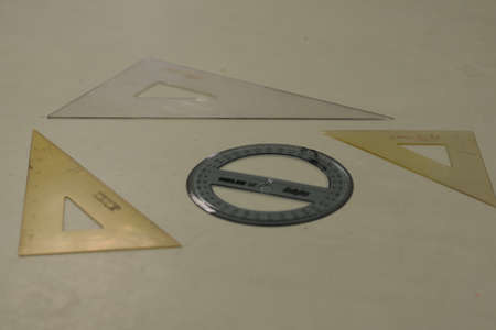 A top view shot of triangular and round rulers  lying on the table