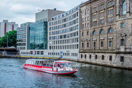 A wide angle shot of a skip sailing next to a buildingの写真素材