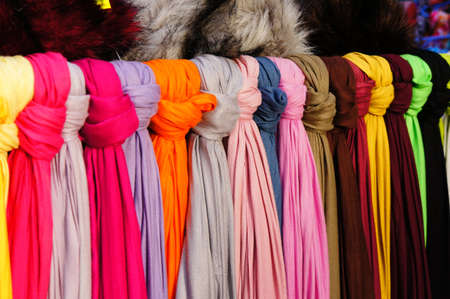 A beautiful shot of colorful scarfs hanging side by side in the storeの写真素材