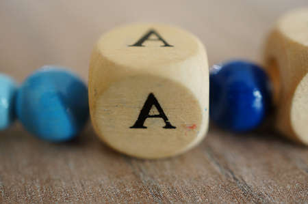 A closeup shot of a cube with a letter on it surrounded by blue circlesの写真素材