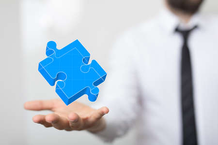 An illustration of a blue piece of a jigsaw puzzle over a person's handの写真素材