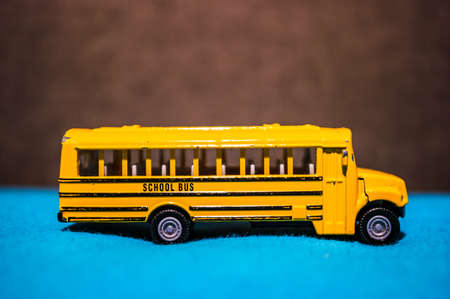 POZNAN, POLAND - Feb 03, 2020: Yellow Siku toy model school bus in soft focus background.の写真素材