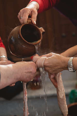A vertical closeup of people washing raw meat with hot water under the lightsの写真素材