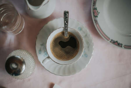 A top view shot of hot coffee served in elegant white porcelain chinaware setの写真素材