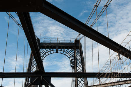 The Vizcaya Bridge under a cloudy sky and sunlight in Getxo in Spainの写真素材