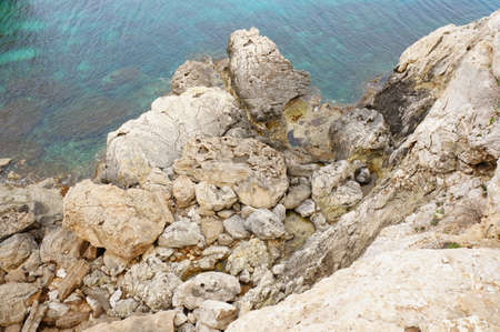 A beautiful shot of the rocks on the shore of a clear lake