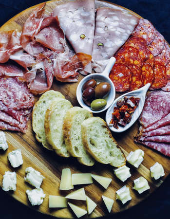 A high angle view of appetizers on a wooden board under the lightsの写真素材