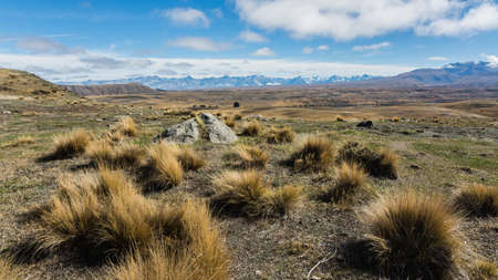 A beautiful shot of an empty field with mountains in the backgroundの写真素材