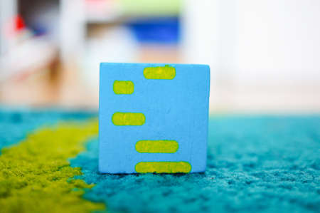 A closeup shot of a blue and yellow cube over a blue surface