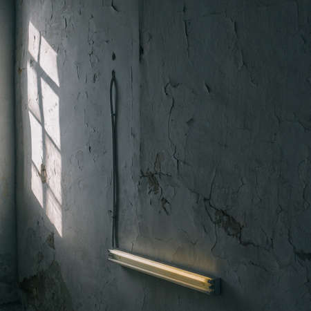 The light of the sun mirrored on the wall of an old building through the windowの写真素材