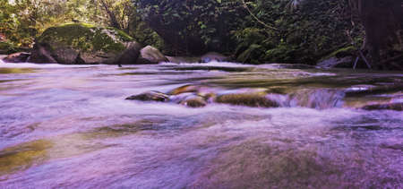 A wide angle shot of a river surrounded by rocks and stones